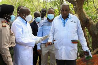 Kenya's Interior Minister Kithure Kindiki talks to forensic experts and homicide detectives from the Directorate of Criminal Investigations, as they prepare to exhume bodies of starvation cult victims, in Kilifi