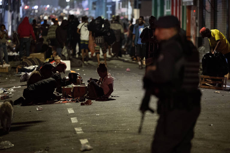 Policial militar acompanha fluxo de usuários de drogas na rua dos Gusmões, no centro de São Paulo 