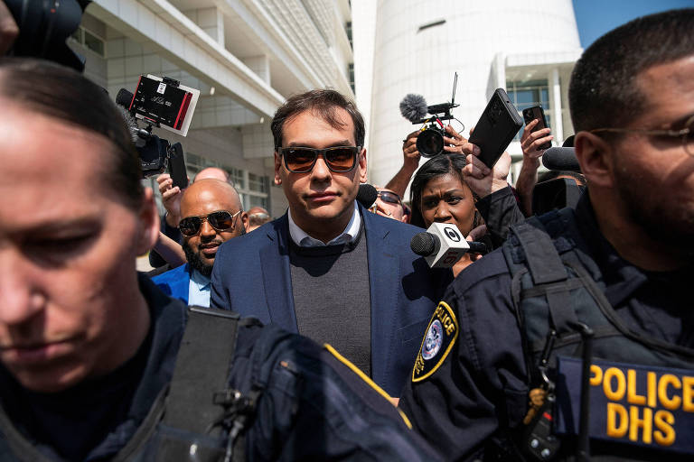 O deputado republicano George Santos é escoltado pela polícia em Central Islip, Nova York, enquanto deixa tribunal 