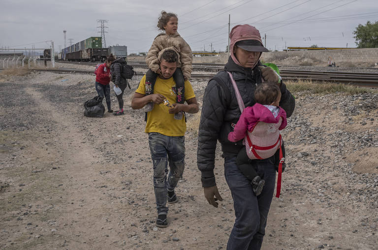 Venezuelanos caminham perto dos trilhos do trem depois de chegarem em um trem de carga em Ciudad Ju‡rez, no México