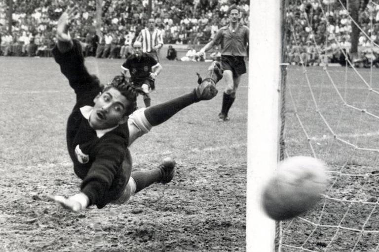 Vestindo uniforme preto, o goleiro Antonio Carbajal, que defendeu a seleção mexicana em cinco Copas do Mundo, de 1950 a 1966, salta para tentar fazer defesa