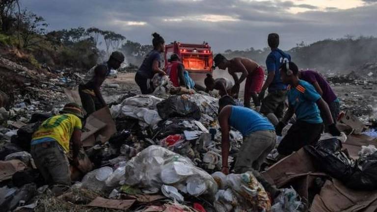 Perto da fronteira da Venezuela com o Brasil, grupos de venezuelanos são vistos procurando alimentos ou produtos recicláveis no lixo