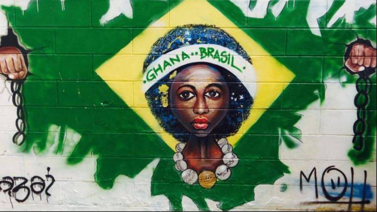 Grafite nas ruas de Acra mostra uma mulher desenhada no centro da bandeira do Brasil, com o cabelo representando o círculo central