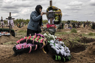 Tamara Smoliarchuk mourns at the grave of her niece, Olena Kyrpychenko, a teacher who was killed Friday by Russian shelling, in the main cemetery in the southern Ukrainian city of Kherson, May 9, 2023. (Finbarr O?Reilly/The New York Times)