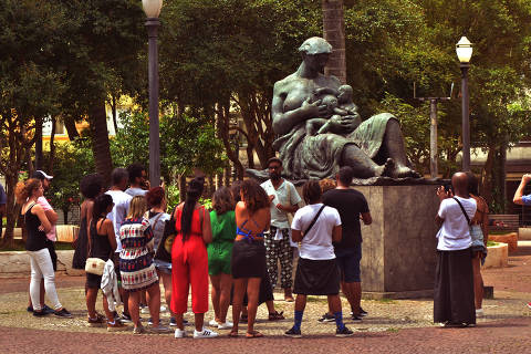 Turistas em frente a Estátua da Mãe Preta, em São Paulo