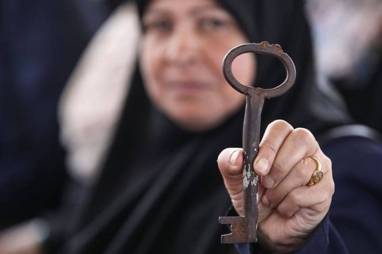  Mulher de hijab (véu islâmico) preto segura chave de metal
