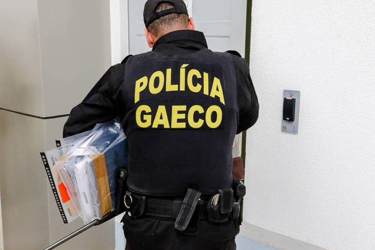 Agente do Gaeco (Grupo de Atuação Especial de Combate ao Crime Organizado) de Goiás recolhe documentos durante operação Penalidade Máxima, que investiga fraudes dm apostas no futebol 