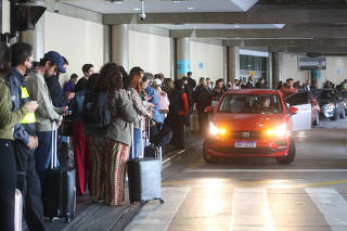 Passageiros aguardam carros de aplicativos em aeroporto de SP