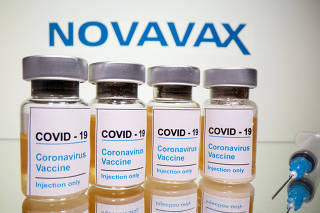 FILE PHOTO: FILE PHOTO: Vials and medical syringe are seen in front of Novavax logo in this illustration