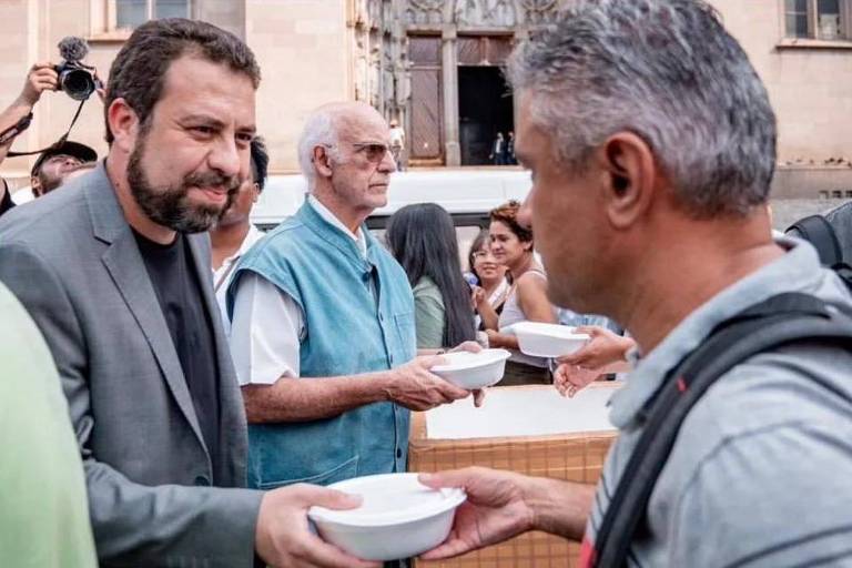 O deputado federal e o padre Júlio Lancellotti distribuem marmitas na praça da Sé