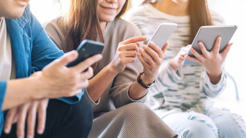 Group of people using and looking at mobile phone and tablet pc while sitting together
Credit  Farknot Architect / Adobe Stock