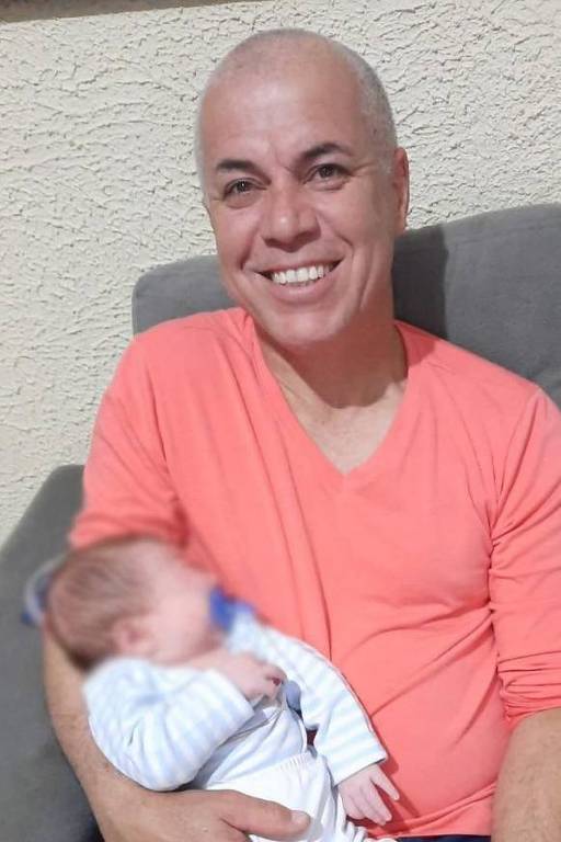 Sargento Gouveia sorri com um bebê no colo