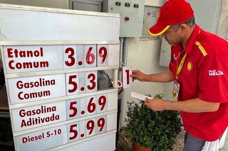 Frentista troca letreiro de preços dos combustíveis no posto Shell