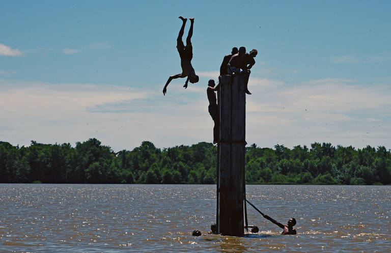 Garotos brincam no rio Paracauari, que separa as cidades de Salvaterra e Soure, na Ilha do Marajó, no Pará