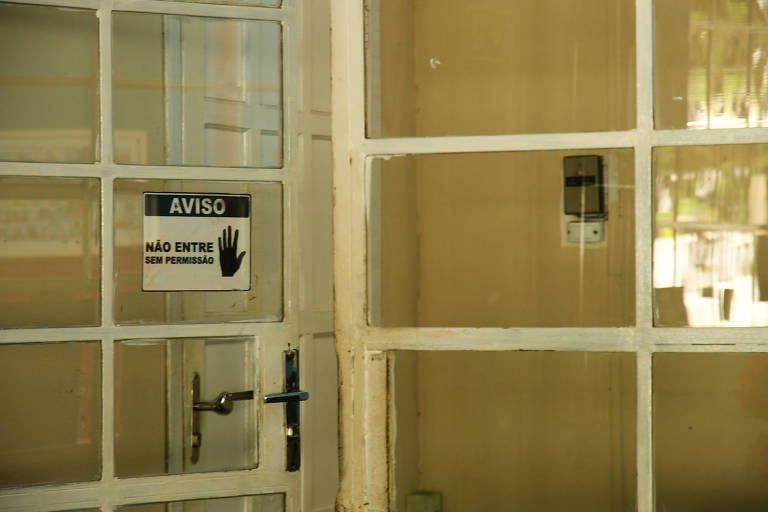 Porta de vidro aberto aberta; em uma delas, há um adesivo com a mensagem de que não se deve entrar sem permissão