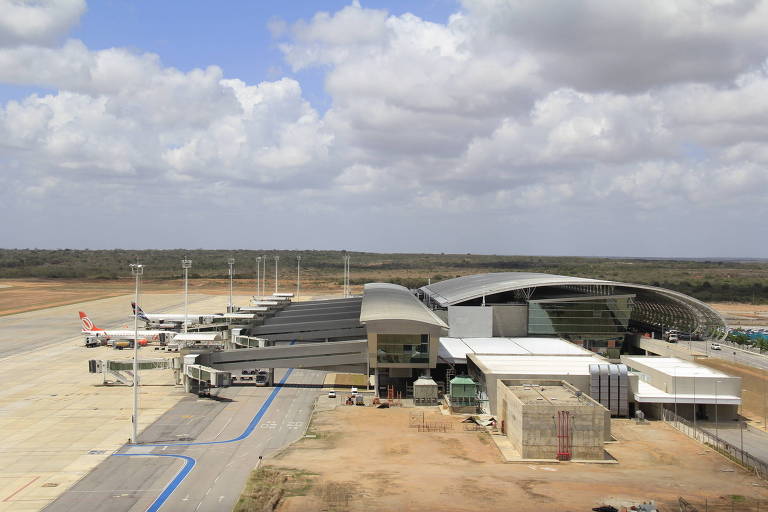 Vista externa do Aeroporto de São Gonçalo do Amarante, na região metropolitana de Natal; aparecem dois aviões parados ao lado do terminal