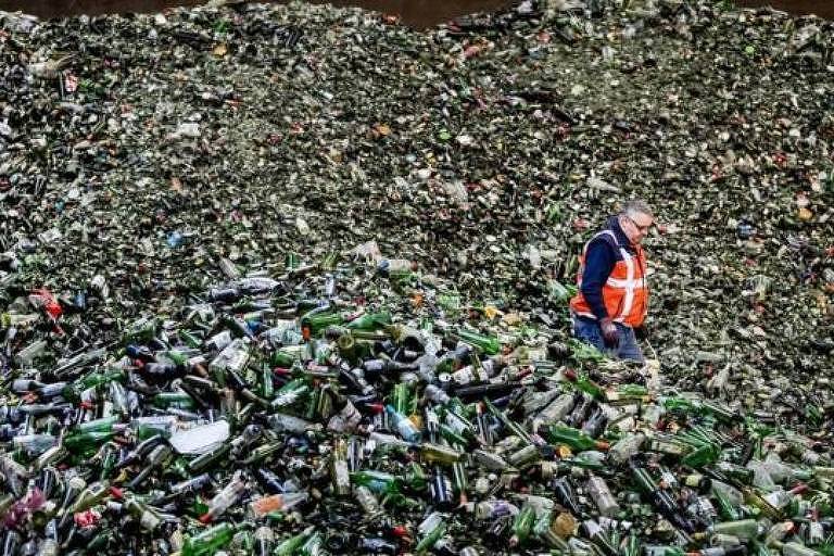 Homem caminha por milhões de garrafas de vidro