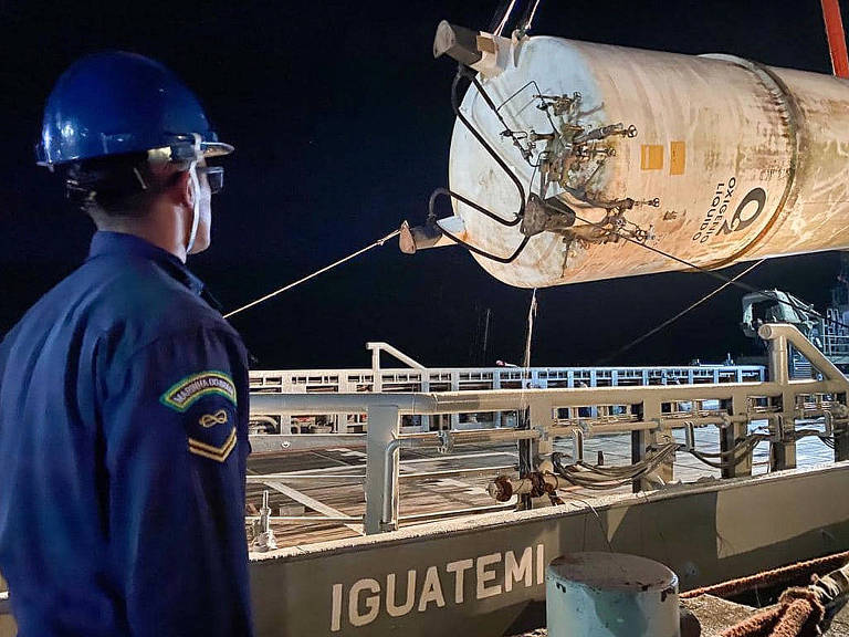 A foto mostra um funcionário da Marinha trabalhando no embarque de cilindro de oxigênio em navio ancorado em Belém (PA) que levará a carga para o Amapá.