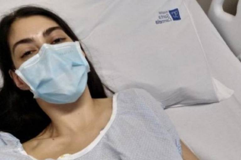 Mulher com máscara na cama do hospital
