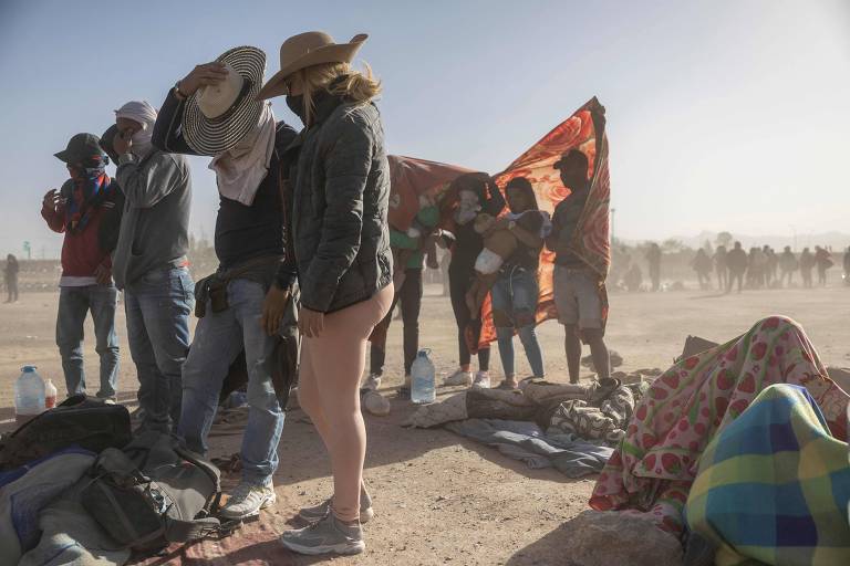 Imigrantes da Venezuela cobrem seus rostos durante tempestade de areia em campo de migrantes em El Paso, no estado americano do Texas