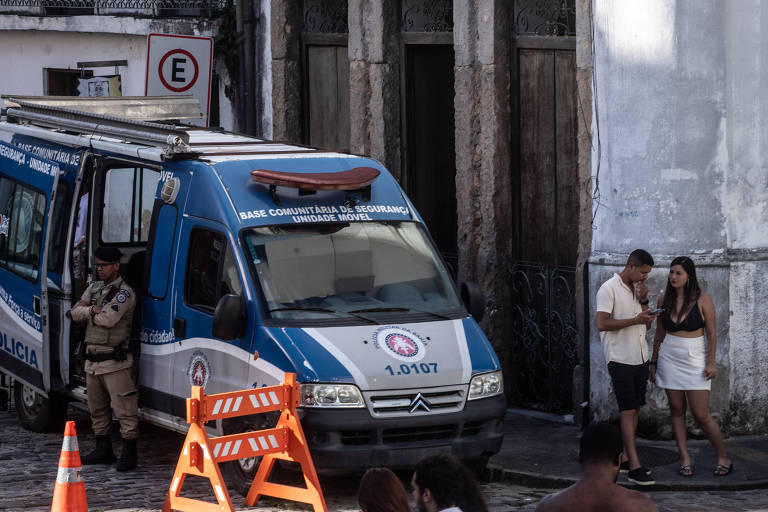 Casal esperando um Uber no Largo do Pelourinho, um dos principais e mais antigos pontos turísticos de Salvador, ao lado de uma base da Polícia Militar