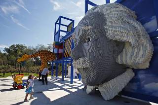 A girl looks at a large bust of Albert Einstein created out of lego bricks at Legoland Florida during its grand opening celebration