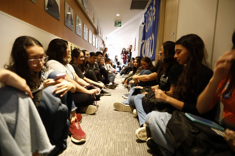 Alunos sentados em um corredor da Faculdade de Ciências Médicas da Santa Casa
