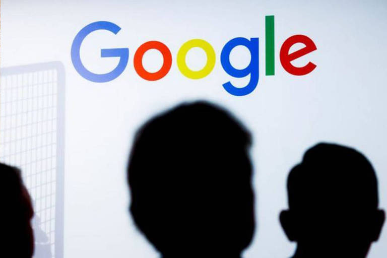Imagem mostra silhueta de três homens à frente de parede branca com logo do Google no terço superior.