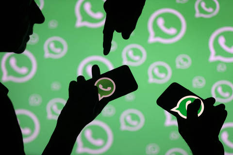 FILE PHOTO: Men pose with smartphones in front of displayed Whatsapp logo in this illustration September 14, 2017. REUTERS/Dado Ruvic/File Photo ORG XMIT: FW1