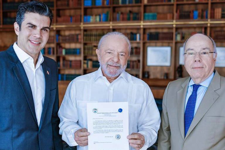 Helder Barbalho, o presidente Lula e o chanceler Mauro Vieira, da esquerda para a direita, posam para foto. lula segura um documento com as duas mãos
