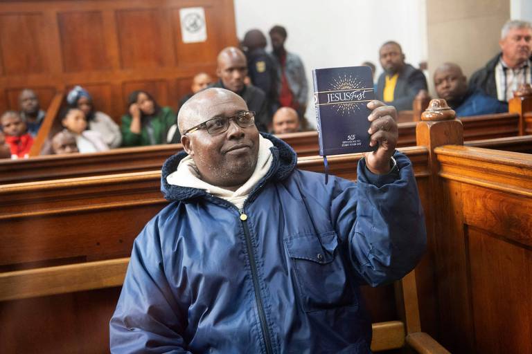 Fulgence Kayishema segura livro cristão em tribunal na Cidade do Cabo