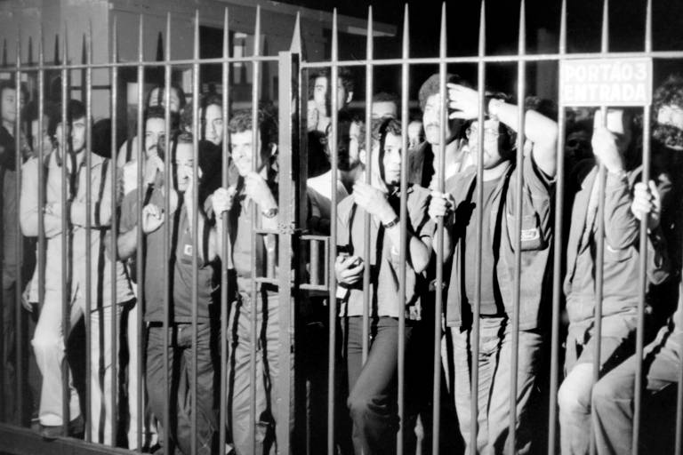 Operários atrás de gradil da Ford após fim de greve na montadora, em São Bernardo