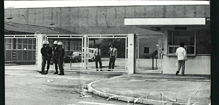 Policiais armados com cassetetes vigiam portão da Saab durante greve