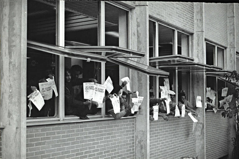 De janelas abertas, grevistas acenam com cartazes que dizem 'tudo parado na Scania', em greve dos anos 1980