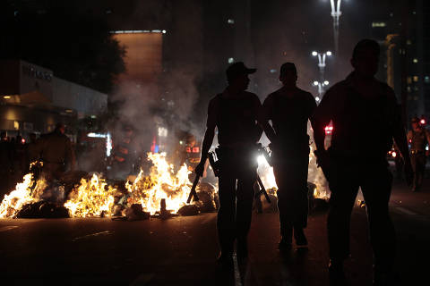 SÃO PAULO, SP, BRASIL, 06-06-2013: País em Protesto: Policiais próximos a barricadas em chamas montadoa por manifestantes durante protesto contra o aumento da tarifa de ônibus, na avenida Paulista, em São Paulo (SP). (Foto: Fabio Braga/Folhapress, COTIDIANO)