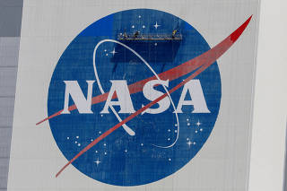 FILE PHOTO: Workers pressure wash the logo of NASA on the Vehicle Assembly Building, in Cape Canaveral