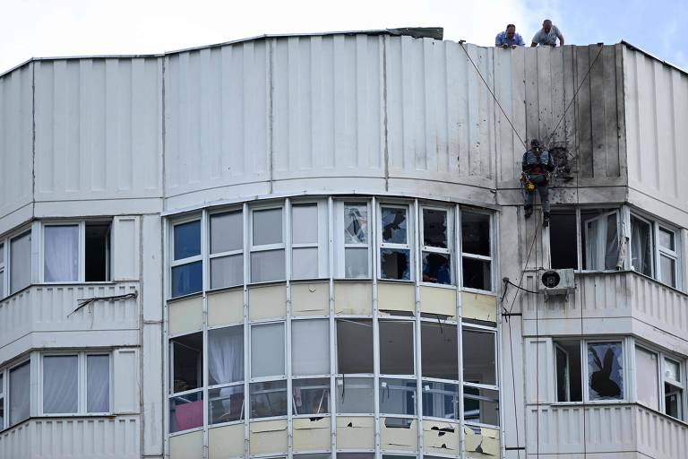 Funcionários inspecionam prédio danificado por drone em Moscou