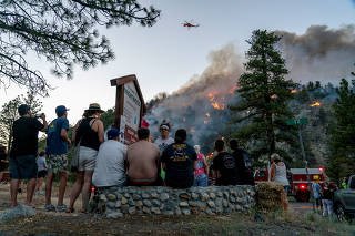 FILE PHOTO: Residents watch part of the Sheep Fire wildfire burn through a hillside in Wrightwood