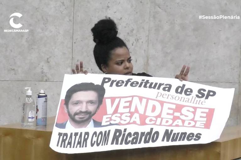Vereadora Luana Alves (PSOL) segurou um cartaz em que acusa o prefeito Ricardo Nunes de vender a cidade