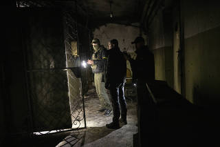 Ukrainian security forces inspect a prison and torture chamber in the bottom floor of an office building where Russian forces reportedly held and tortured Ukrainian prisoners, in Kherson, Ukraine, Nov. 16, 2022. (Lynsey Addario/The New York Times)
