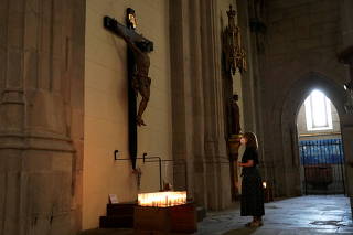 FILE PHOTO: A woman prays inside a church in Spain