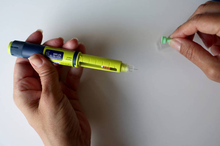 Pessoa segura uma caneta de insulina utilizada no tratamento de diabetes