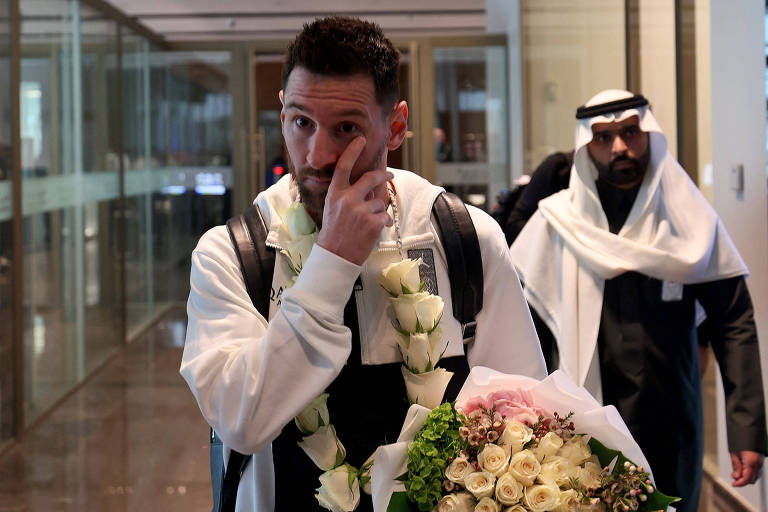 Messi segura flores e mexe no olho no aeroporto de Riad (Arábia Saudita), onde esteve para um amistoso entre o PSG e um combinado Al-Hilal/Al Nassr 