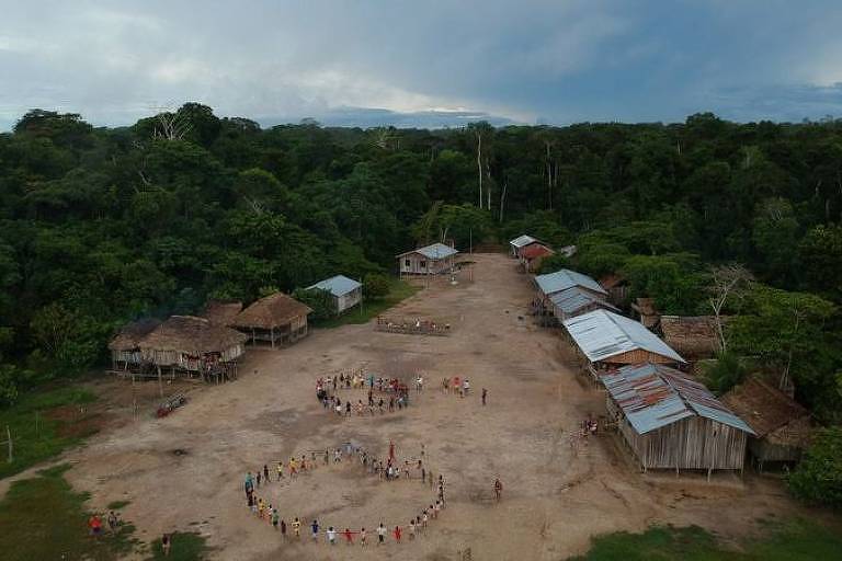 Foto aérea mostra aldeia indígena com pessoas formando duas rodas