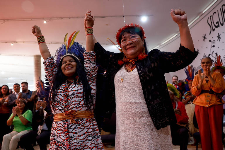 Joenia Wapichana e Sônia Guajajara, respectivamente a presidente da Funai e a ministra dos Povos Indígenas dão as mãos levantadas para cima durante cerimônia de posse de Wapichana