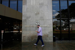 FILE PHOTO: A man walks in front the Central bank headquarters building in Brasilia
