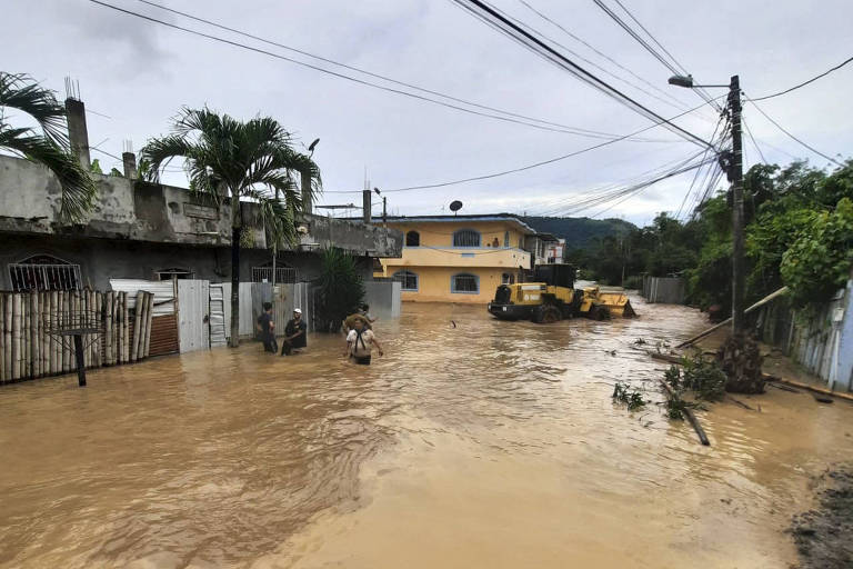 Pessoas andam em enchente na província de Esmeraldas, no Equador