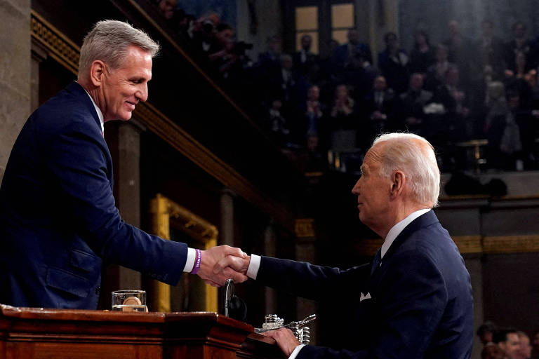 O presidente Joe Biden, à dir., aperta a mão do presidente da Câmara, Kevin McCarthy, após discurso no Capitólio