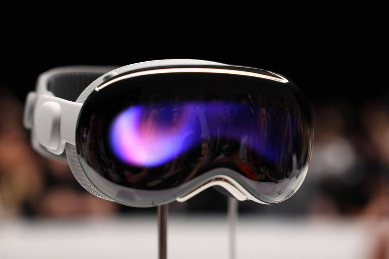 Os novos óculos de realidade aumentada da Apple, em evento realizado pela empresa em Cupertino, EUA. Dispositivo mostra olhos do usuário para mostrar quando ele enxerga o que está à frente. Foto mostra o aparelho diante de uma platéia ao fundo, desfocada