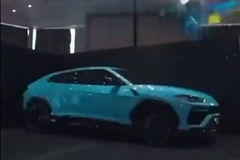 Em foto, um carro de luxo é pintado de azul para chá revelação